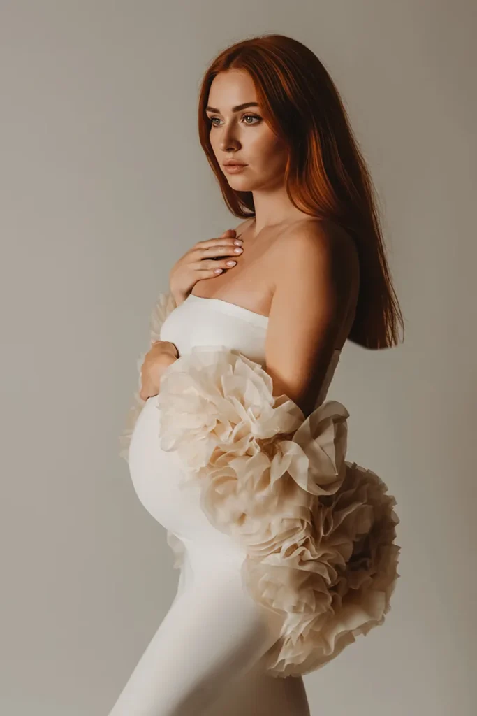 Future maman en robe blanche fleurie lors d’une séance grossesse en studio en Provence