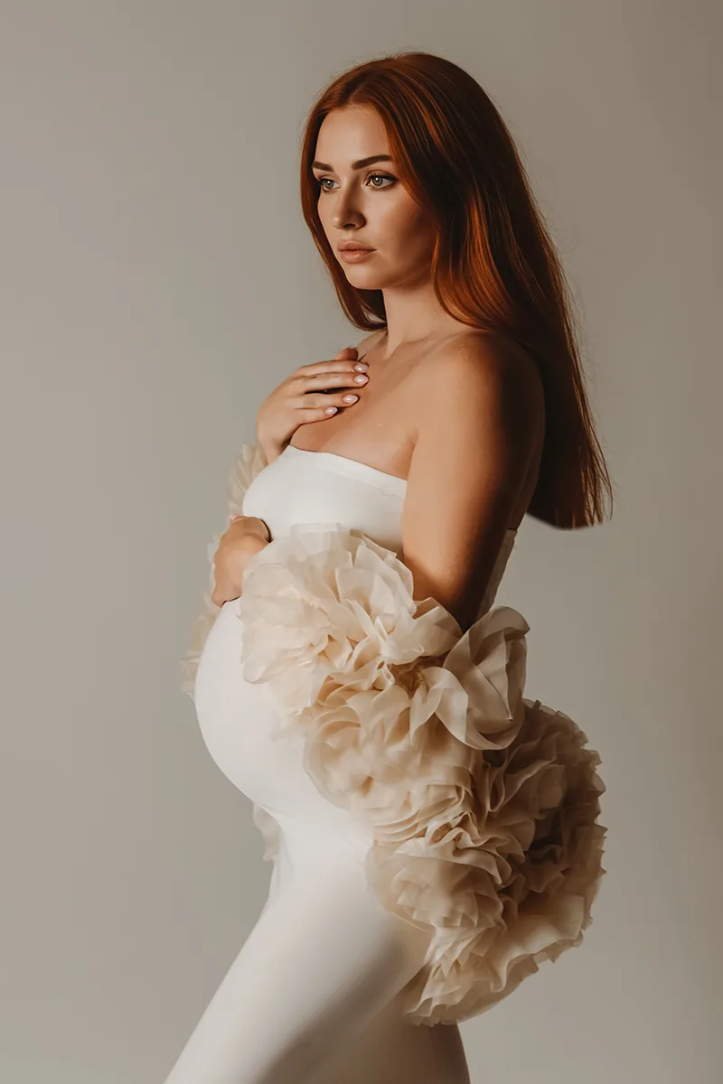 Future maman en robe blanche fleurie lors d’une séance grossesse en studio en Provence